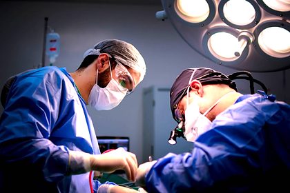Two surgeons operating under theatre lights